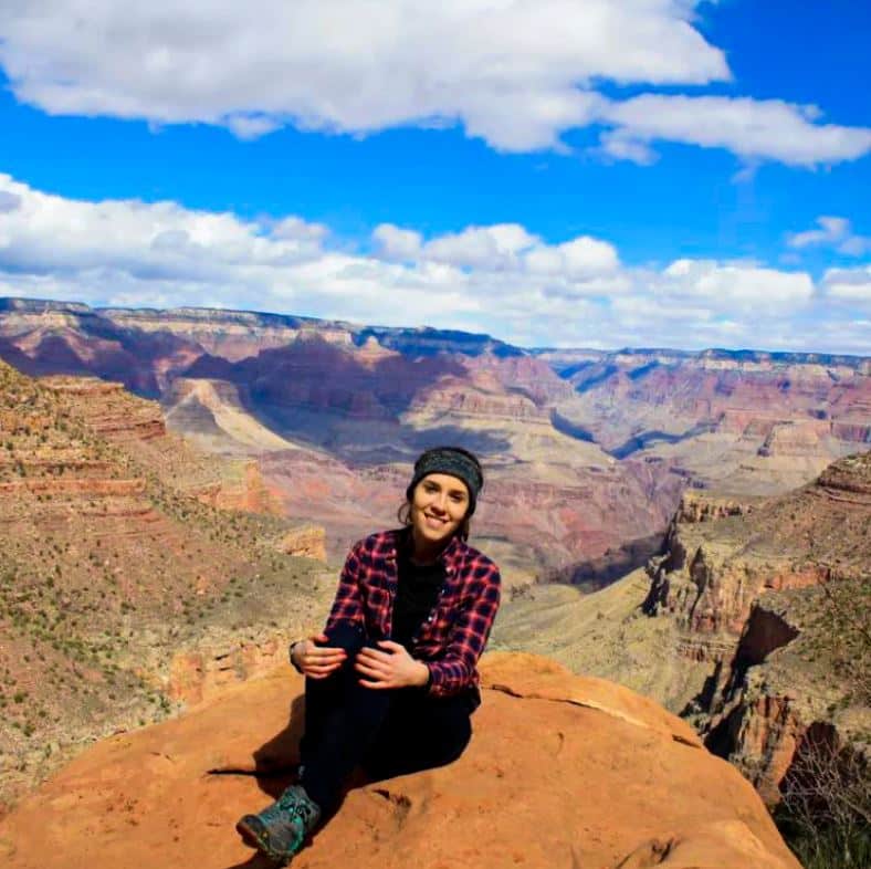 Melanie Gutierrez sitting on cliff in a Canyonland