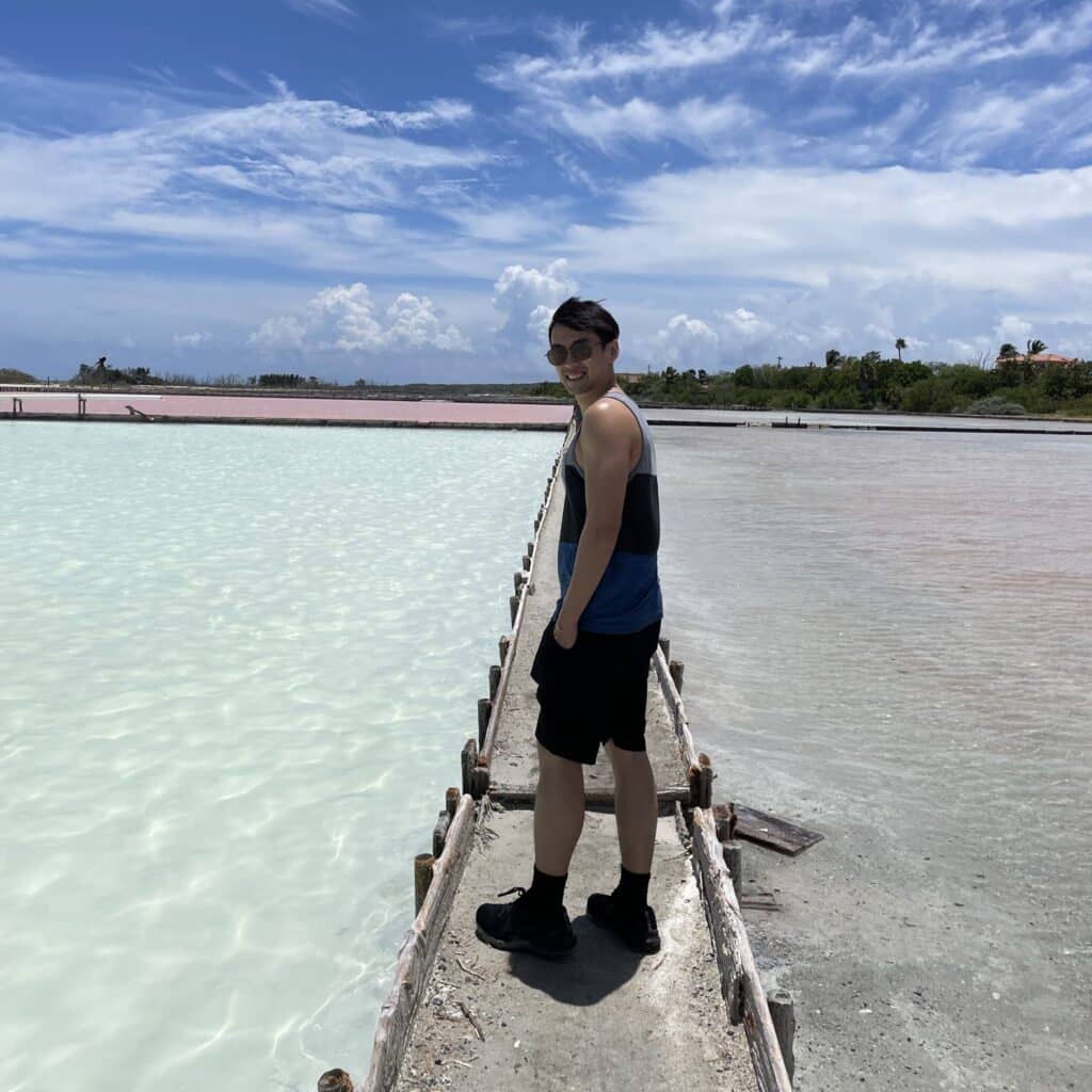 Chon Leong walking along a narrow bridge on the beach