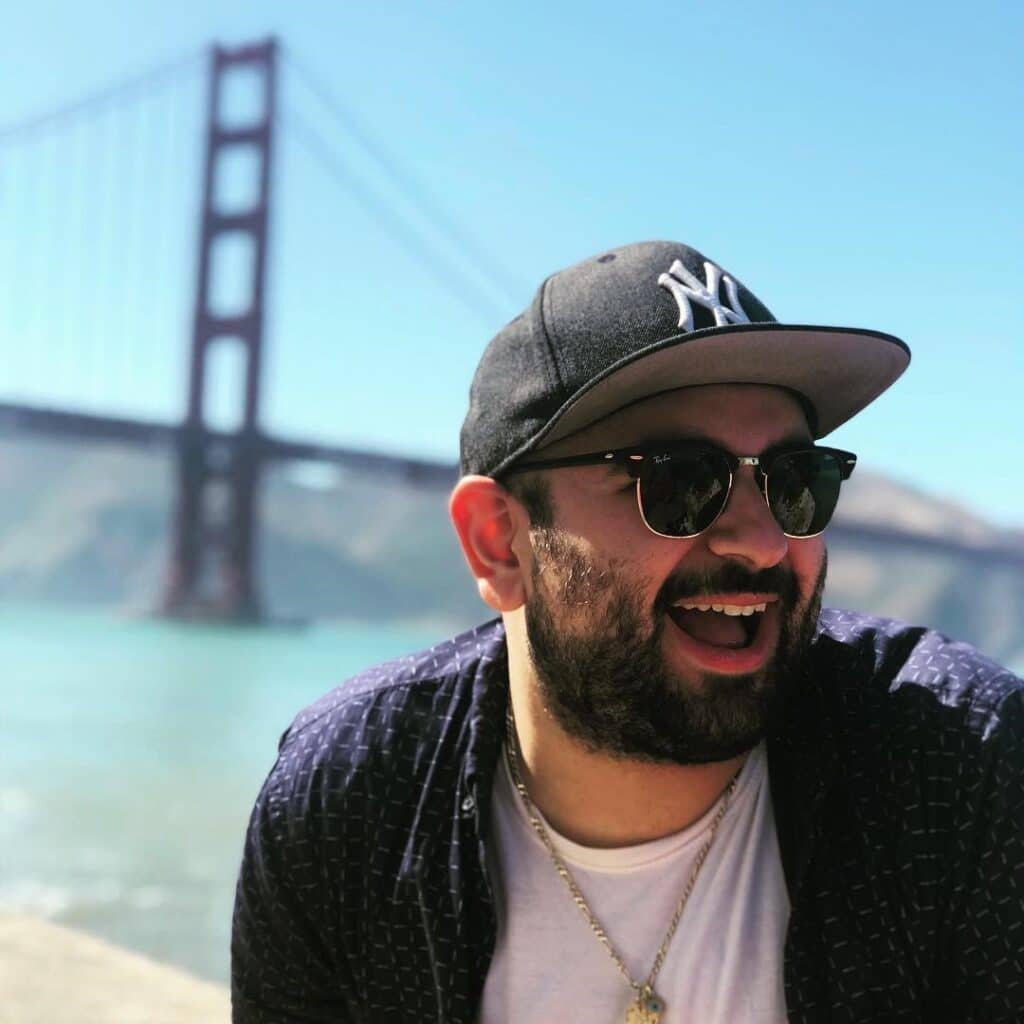 Elias Fraija in a yankee hat in front of the bridge