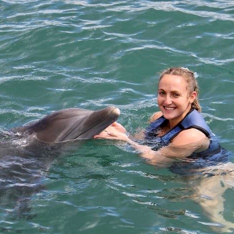 Gabrielle Skolnik petting a dolphin