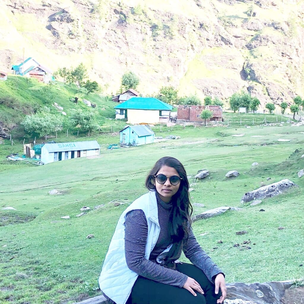 HEENA KALATHIYA squatting in a field