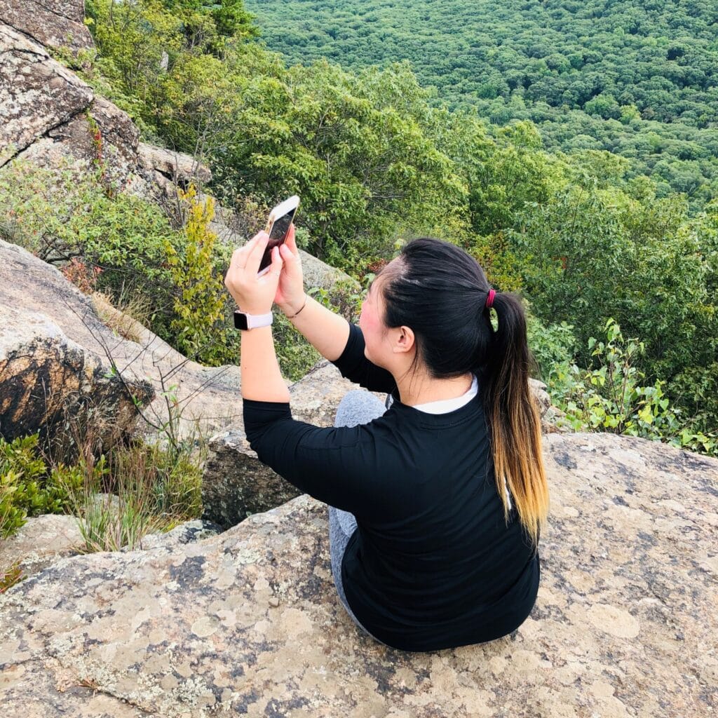 Jenny Leung taking a selfie on a mountain