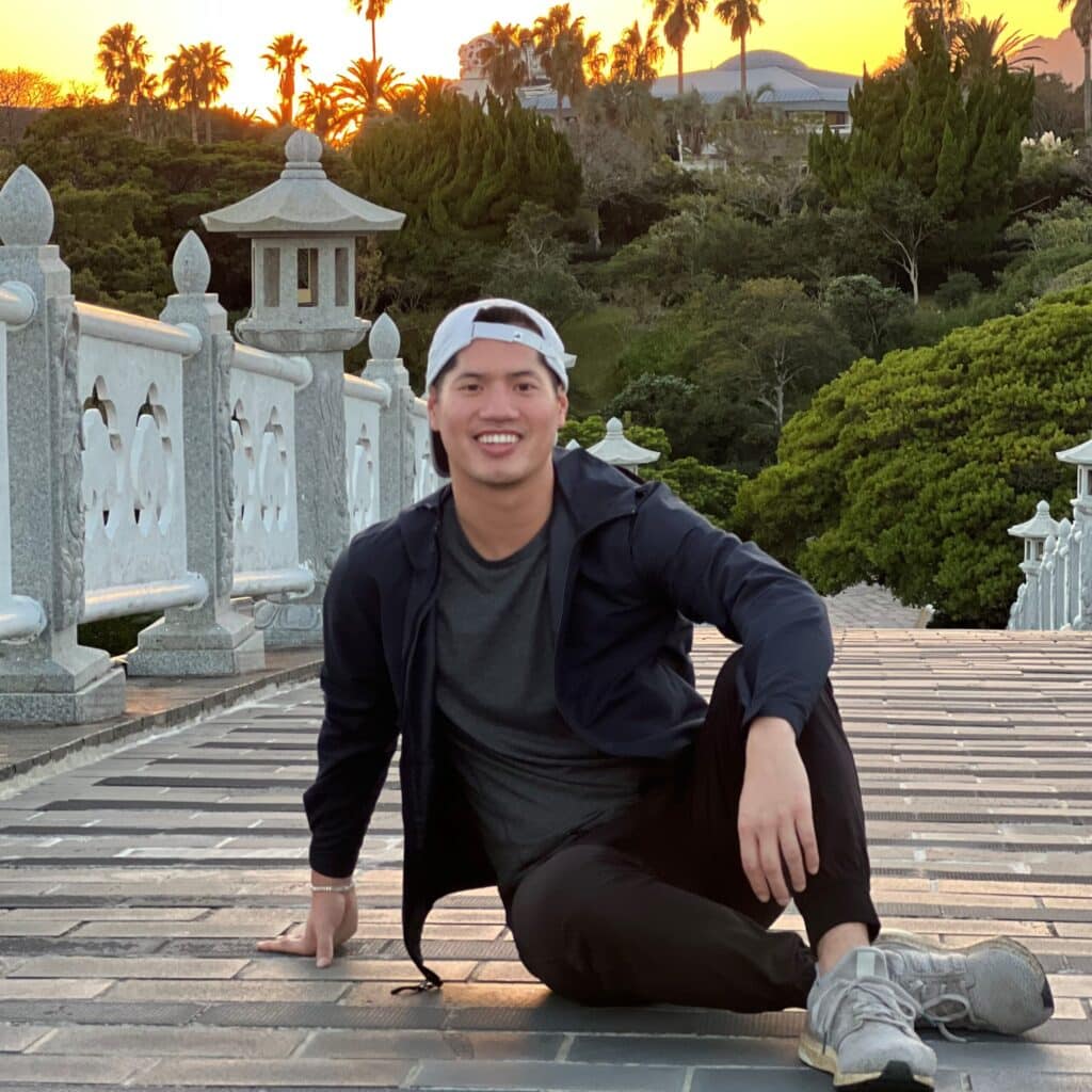 Justin Hoang sitting on a bridge