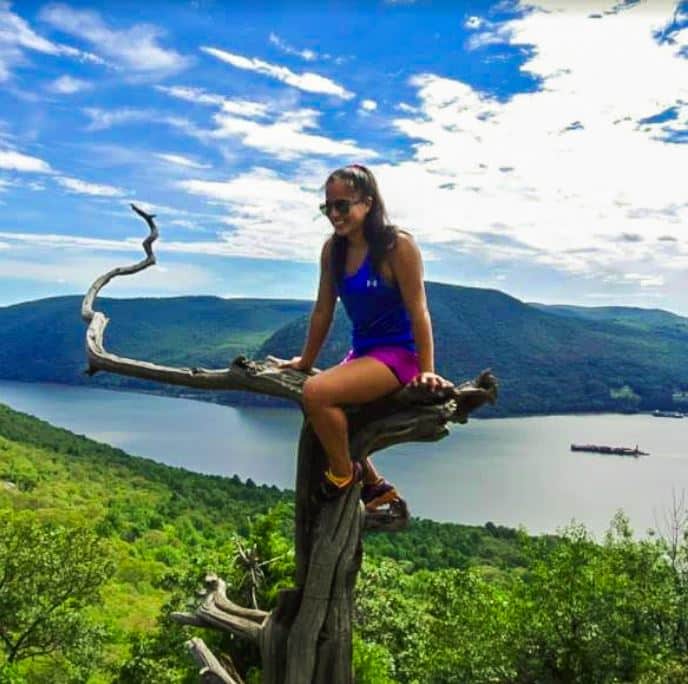 Stefany Ibarra sitting on tree overlooking river