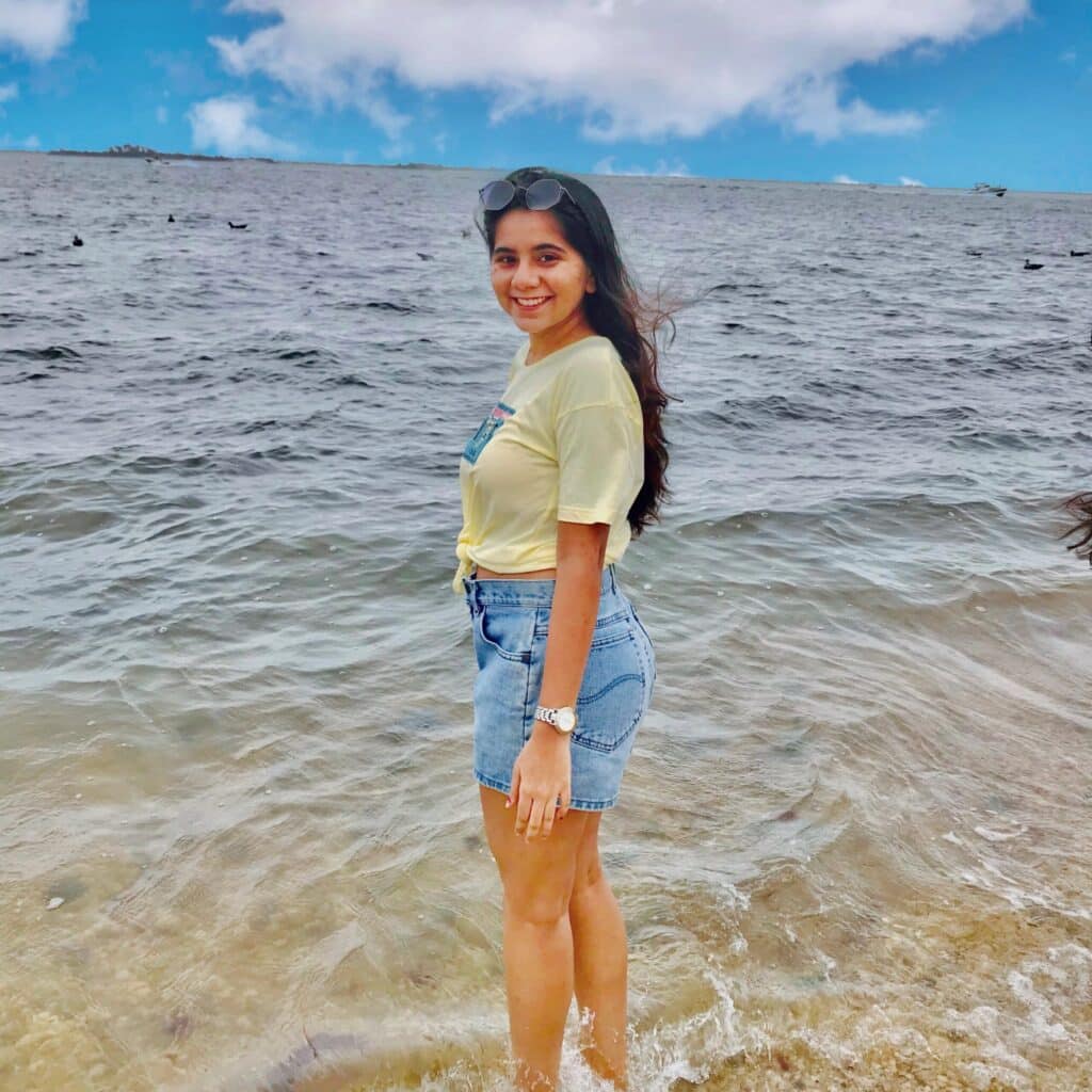 Radhika Thakkar standing in the ocean