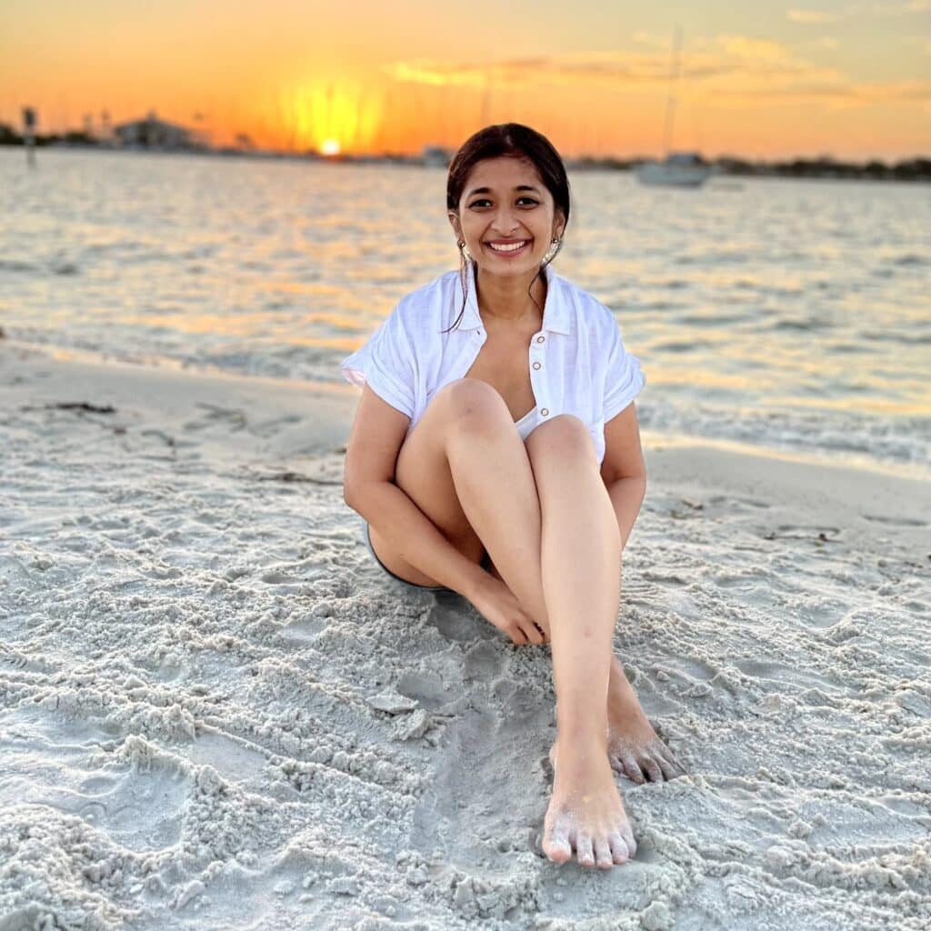 Rajvi Savla sitting on the beach