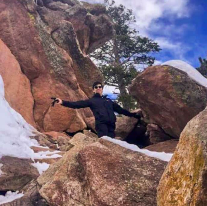 Wilfred Cheung hiking, standing between large rocks