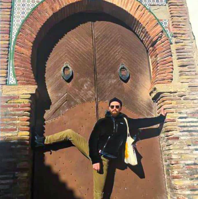 William Klein posing in front of door