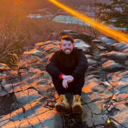 Matthew Dolan sitting on rock during sunset