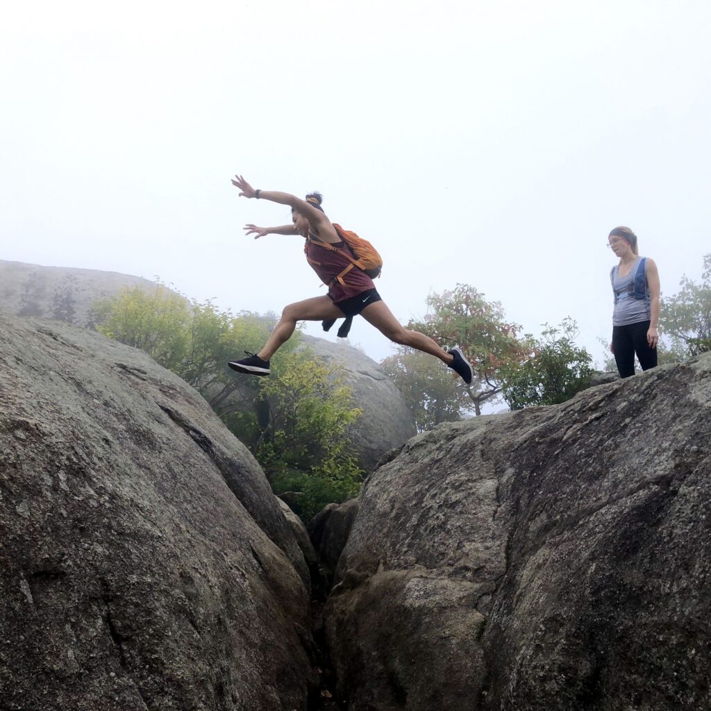 Andrea Kwok jumping from one big rock to another