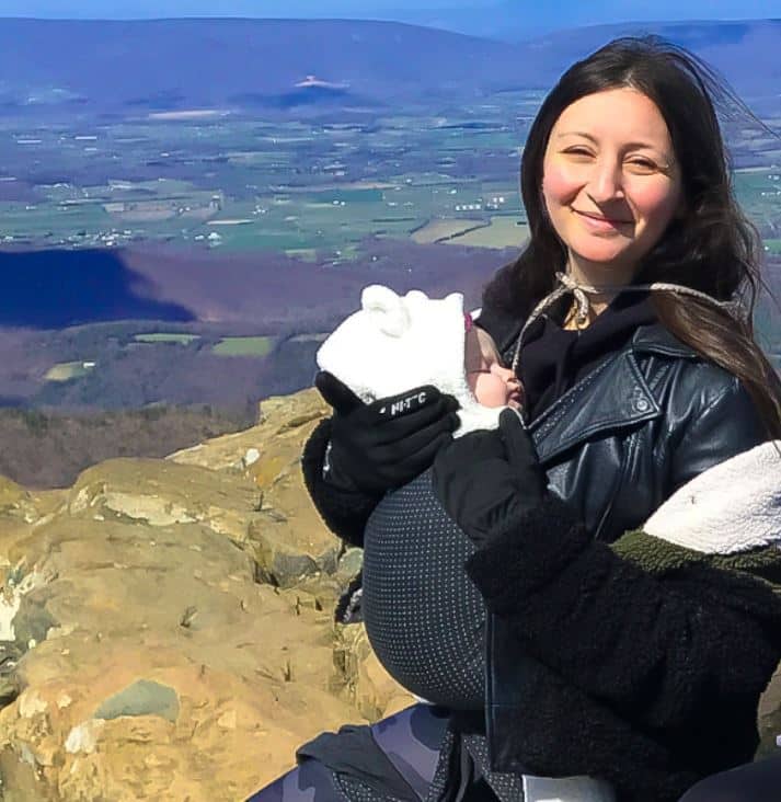 Elana Jonas with baby on a mountain lookout