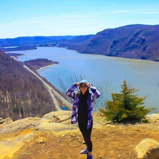 Michelle Sabogal on a mountain top overlooking a river