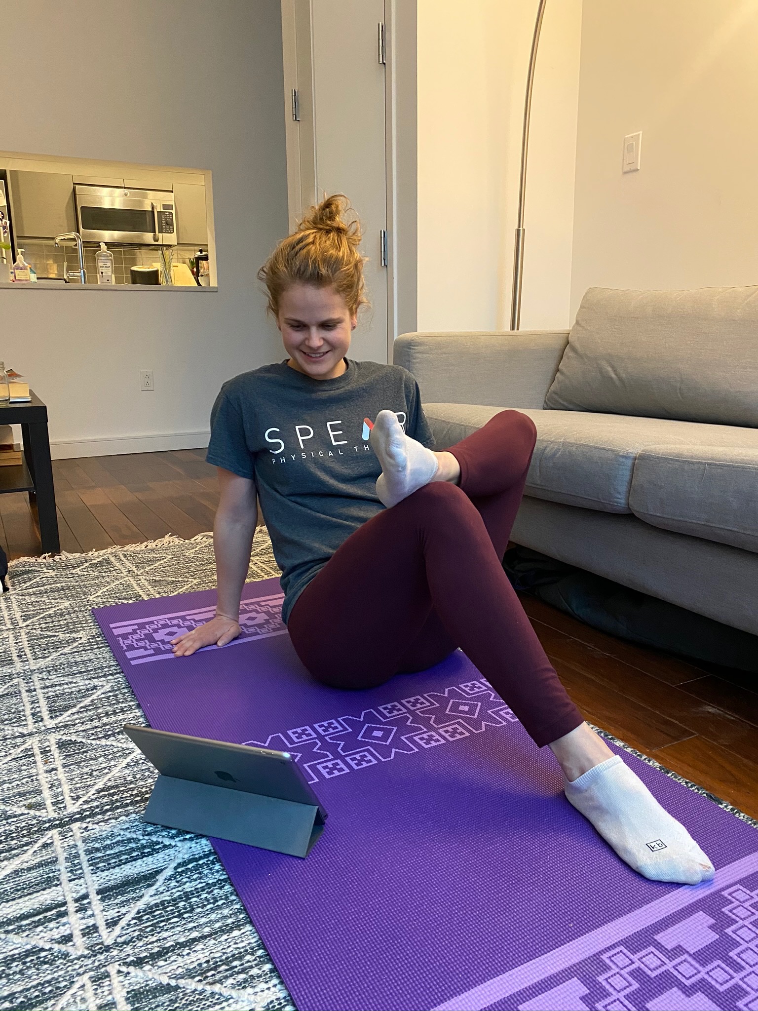 Woman exercising with laptop in living room