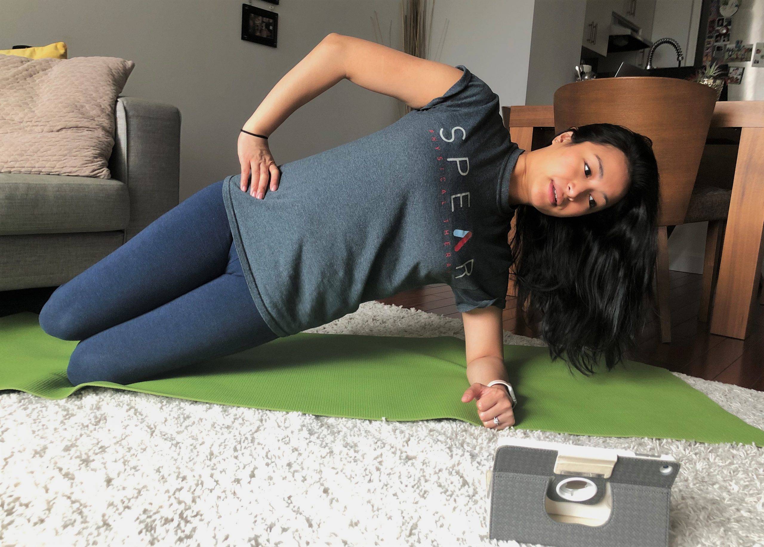 Woman exercising with tablet in living room