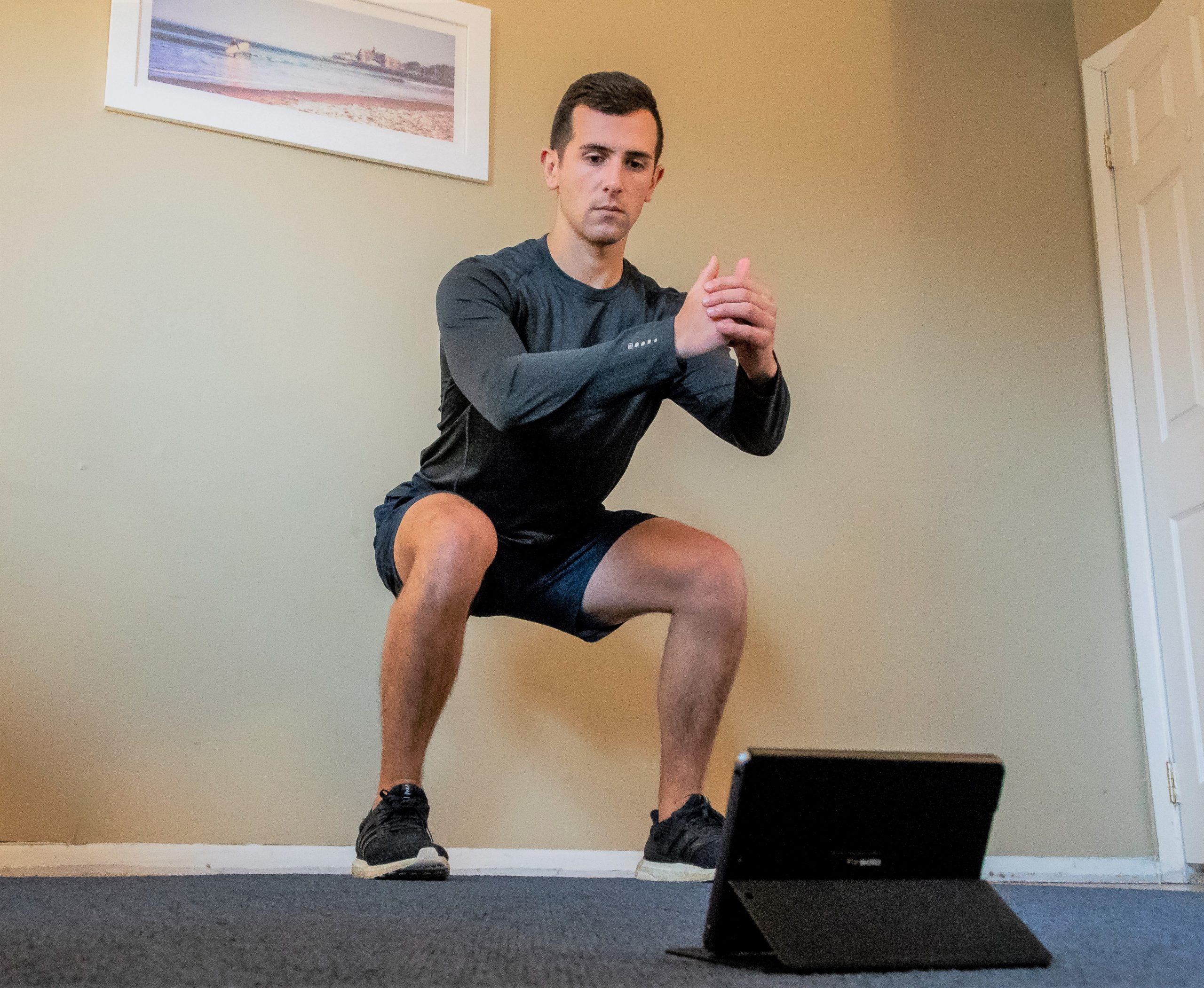 Man exercising with tablet in living room