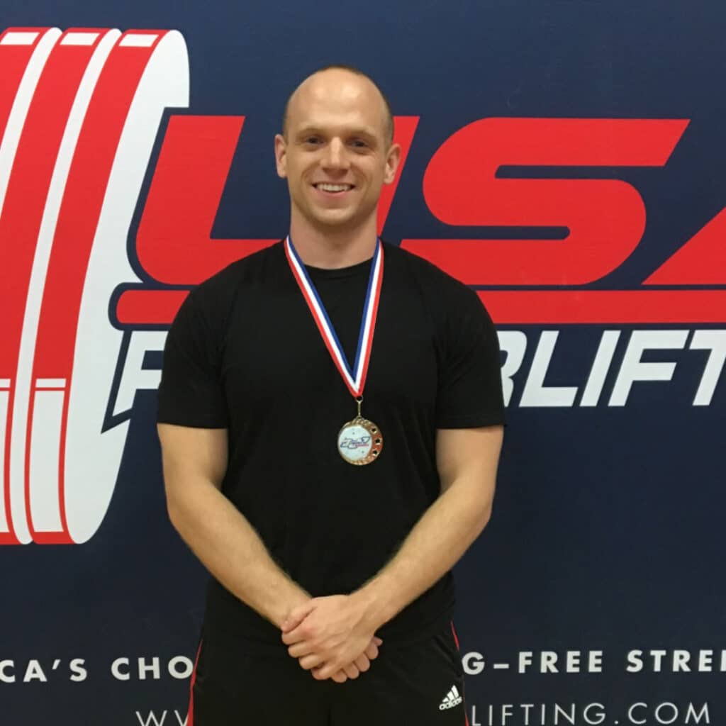 Tom Anderson with medal after weightlifting contest