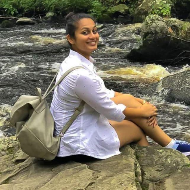 Tulsi Amin posing on rock near creek