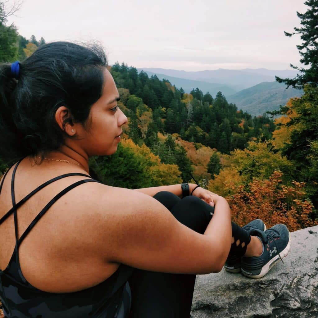 Aakanksha Bhagwat hiking picture overlooking forest in Autumn