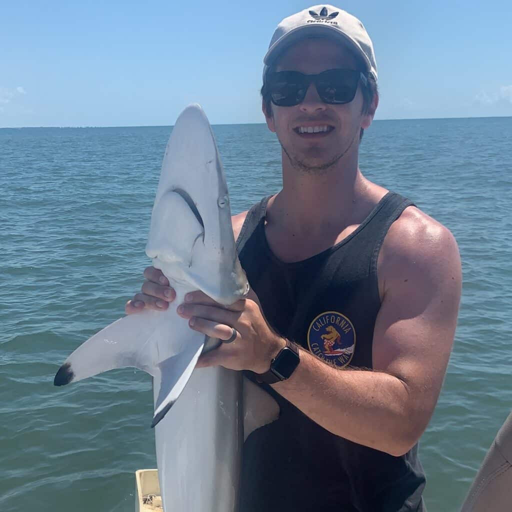 Ben Miles fishing, holding large fish on boat