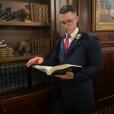 Benjamin Schwartz in library reading a book