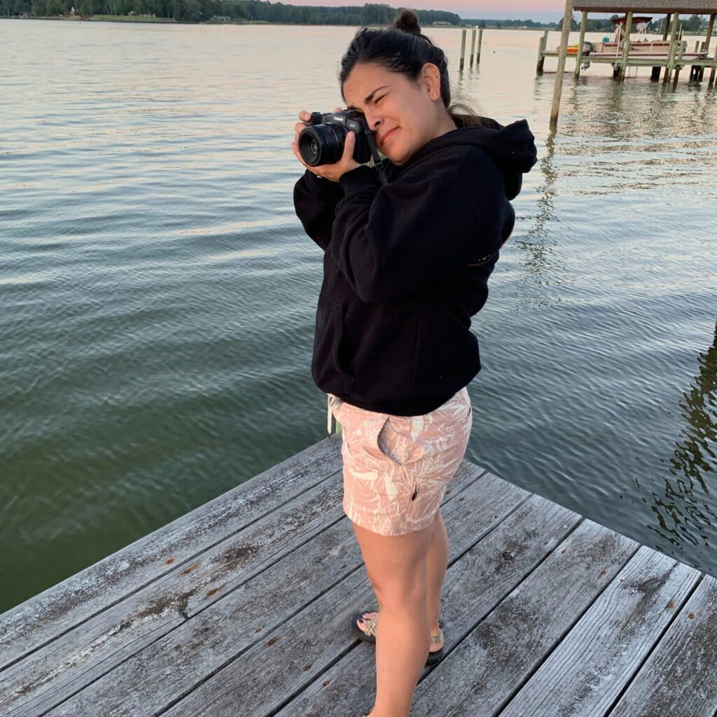 Beth Kines with camera on wooden pier