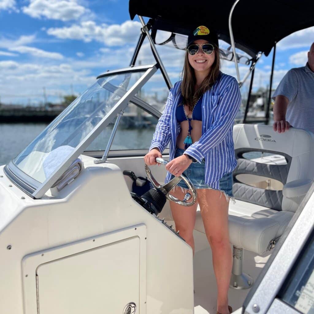 Camryn Gessner on steering wheel of boat