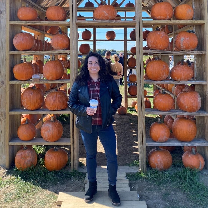 Cassandra Ciorciari with coffee in front of pumpkin display