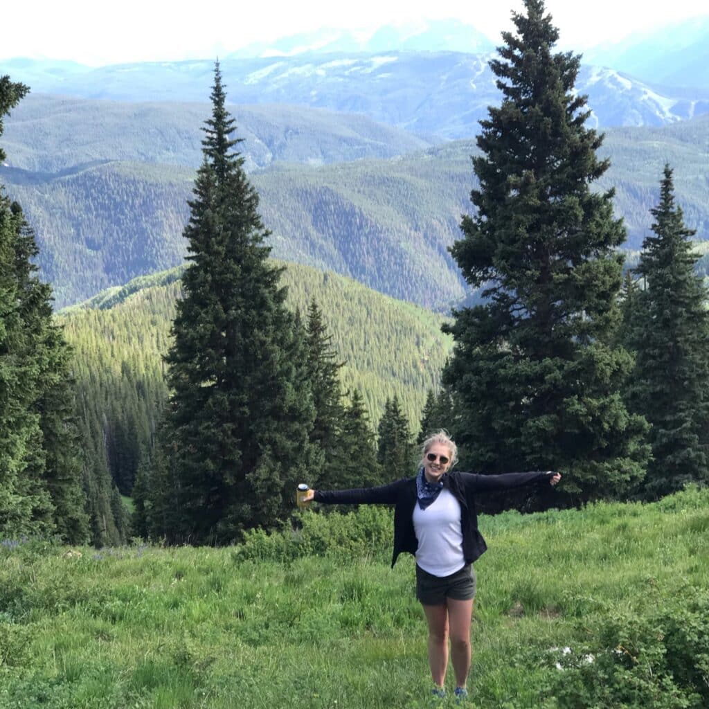 Claire Ruth standing in open field in front of mountains