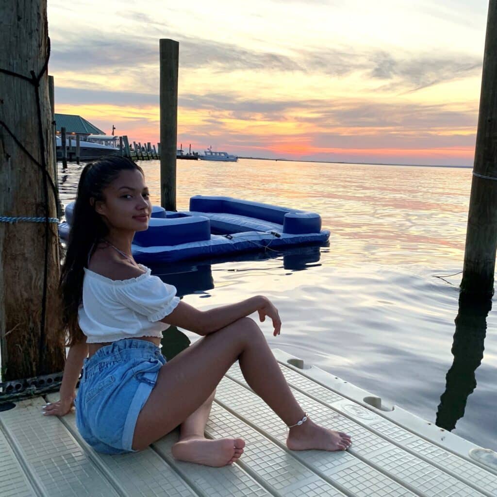 Clara Vargas posing on a pier during sunset