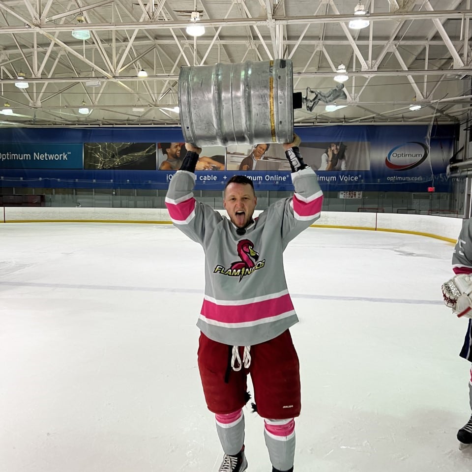 Daniel diner lifting a hockey trophy