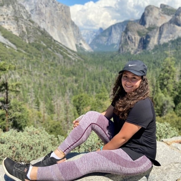 Daniela Osorio sitting on edge of a mountain