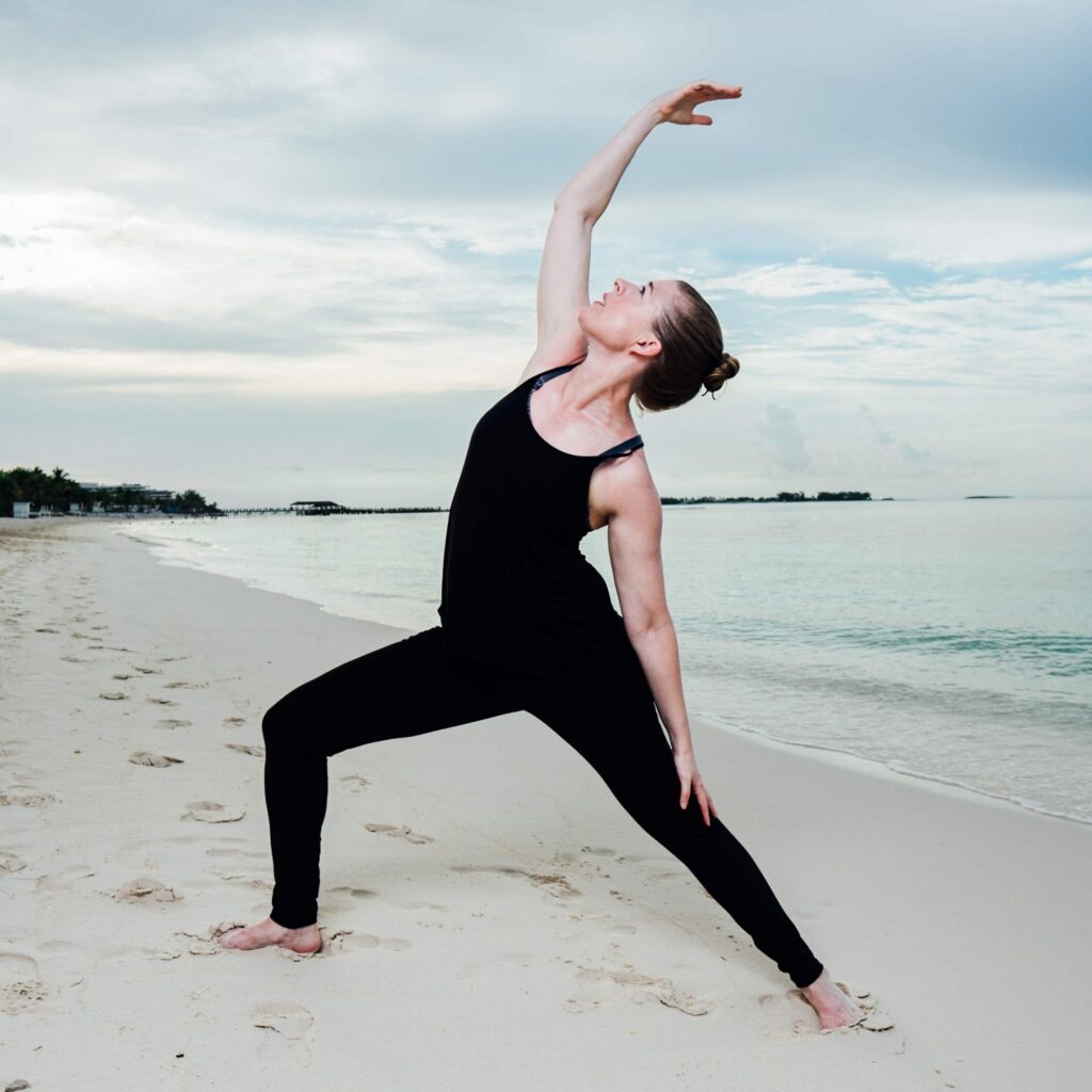 Debra Pritchett yoga pose on beach