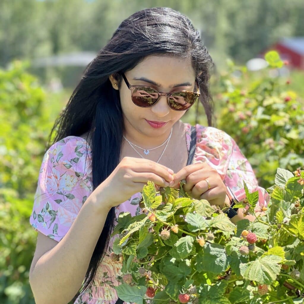 Helly Patel picking berries off a tree