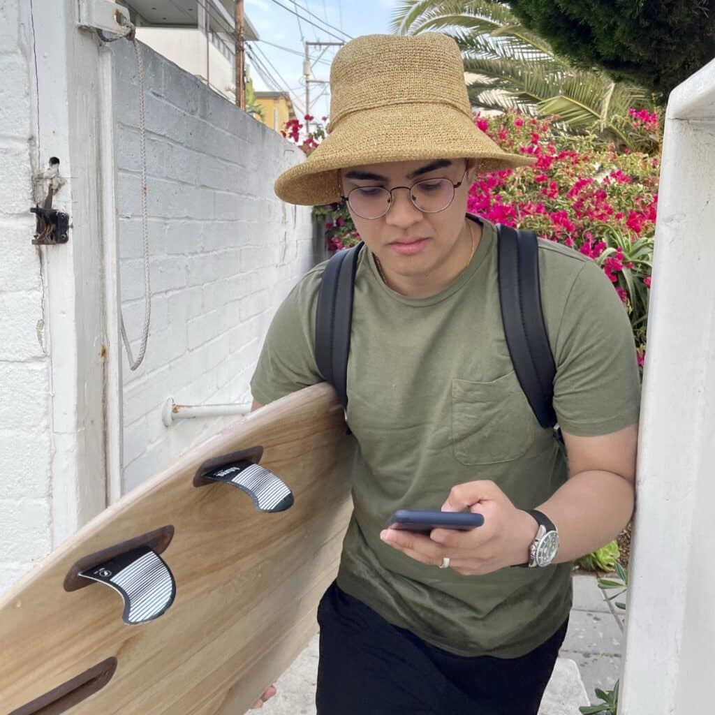 Jericho Mikhail Onglengco carrying a surfboard