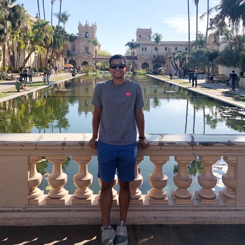 Jesse Ramirez travel portrait standing in front of pool in historic square