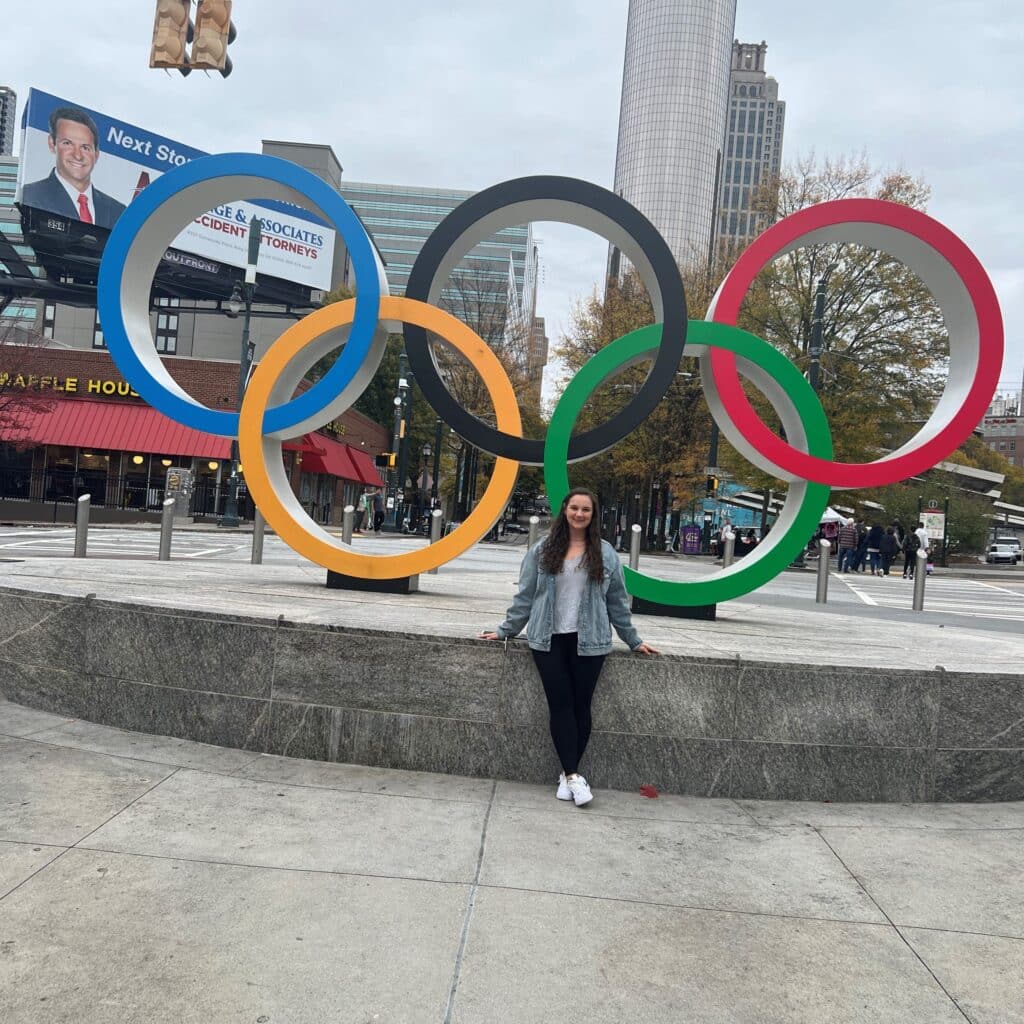 Jess Zaeri in front of Olympic rings in Centennial Olympic Park Georgia