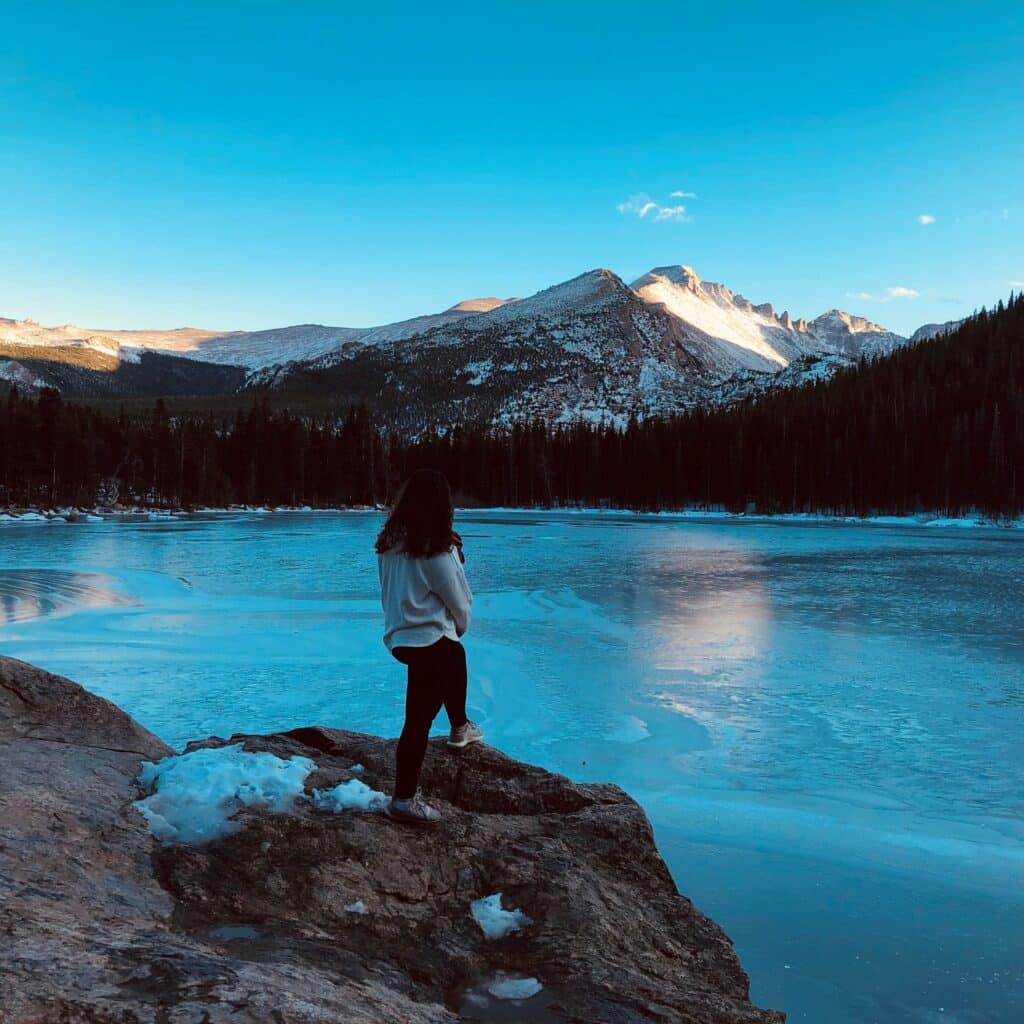 Jessica Zaeri overlooking a frozen lake in the mountains