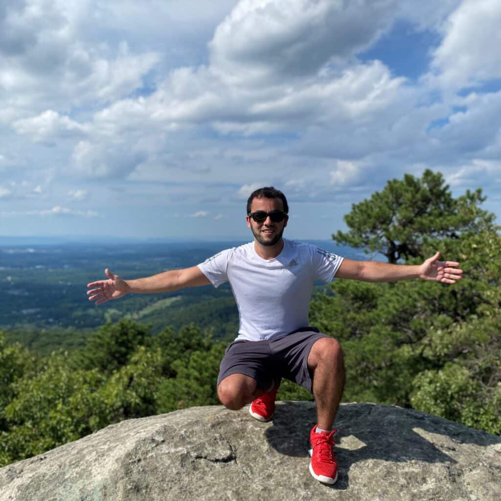 Joshua Pernick on rock overlooking a forest