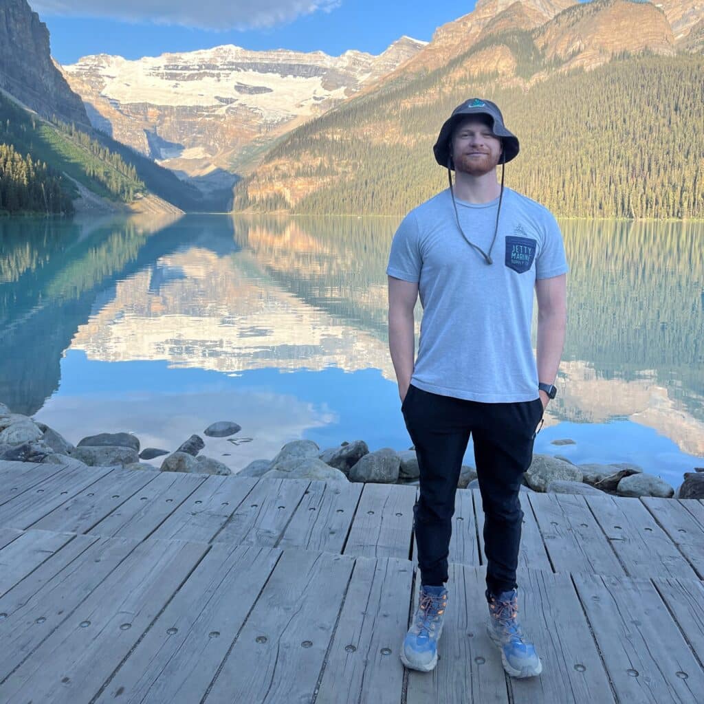 Kevin Lapham in front of glossy mountain lake in the morning