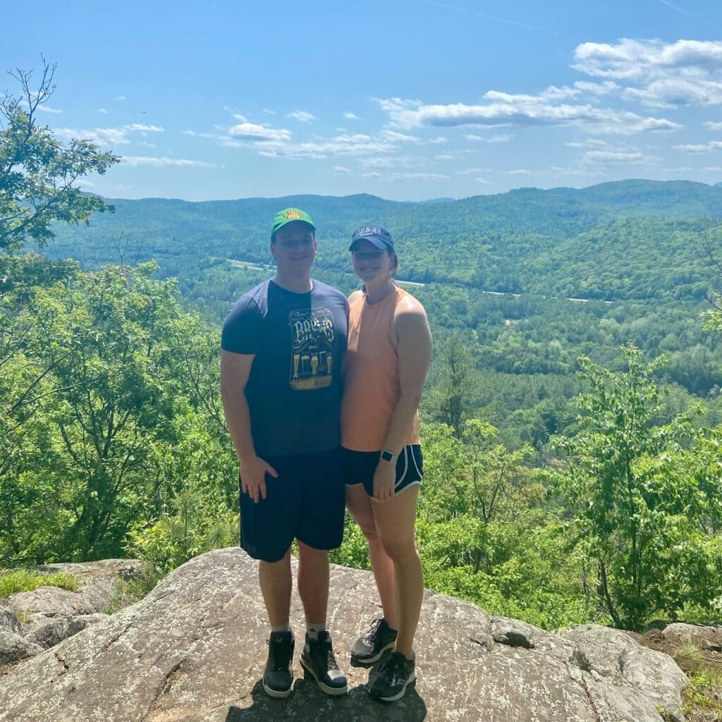 Kim Pyle with friend on mountain top overlooking a forest