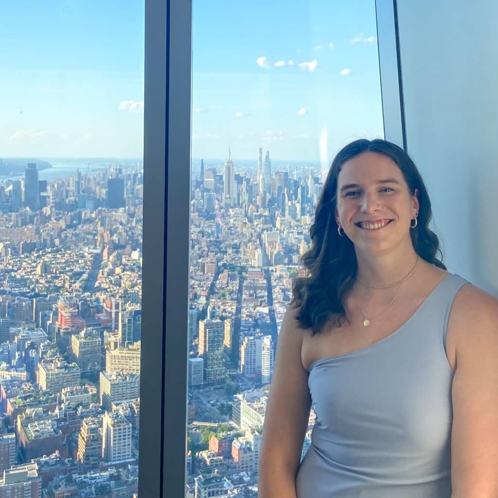 Kim Pyle in a high-rise in front of Manhattan skyline