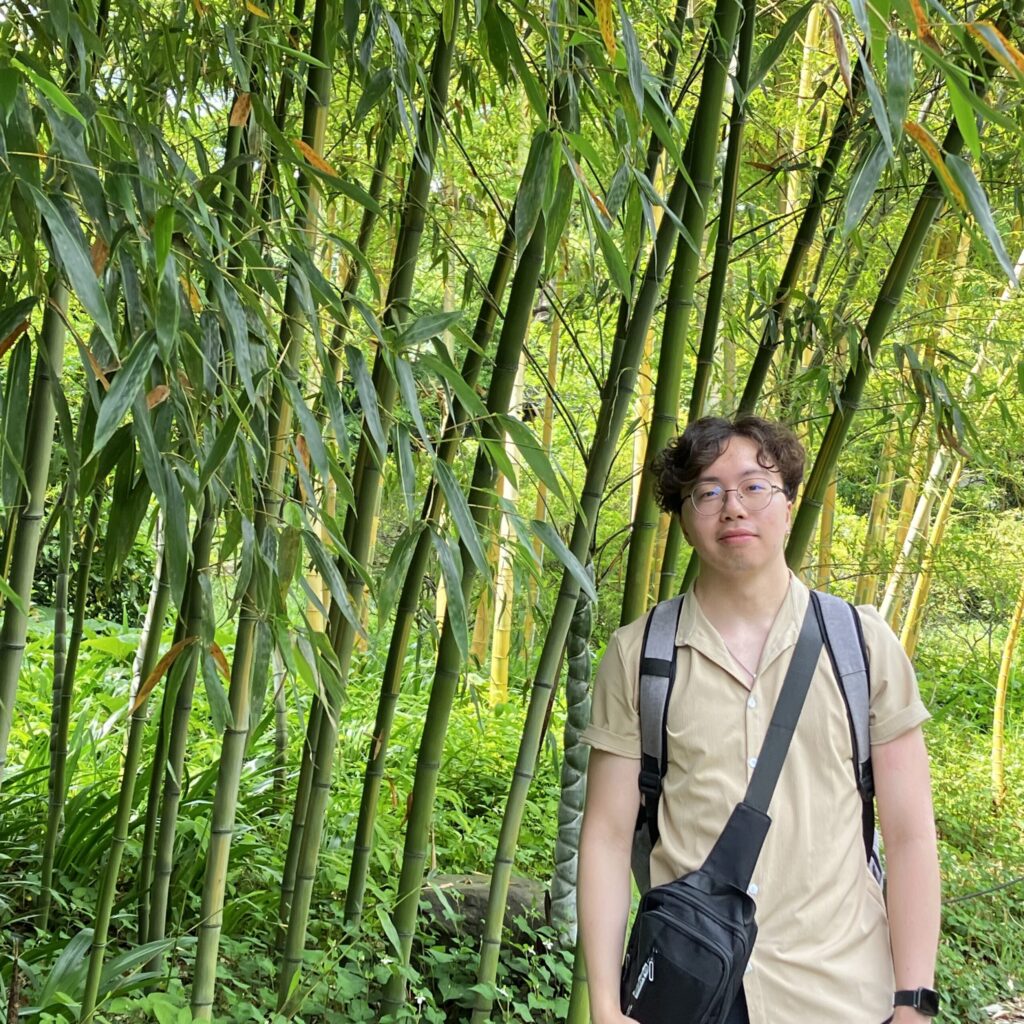 Kingston Wong in front of a large grass field