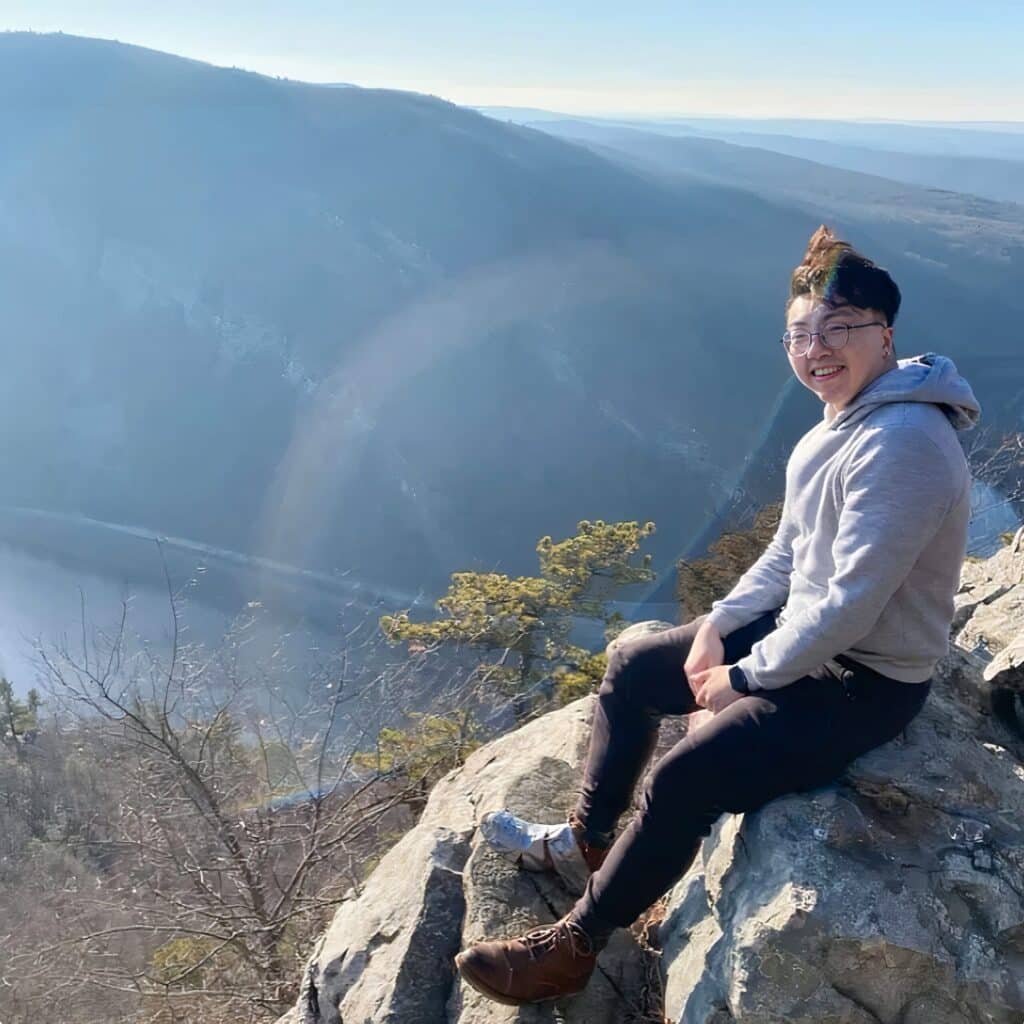 Kingston Wong sitting on top of a rock