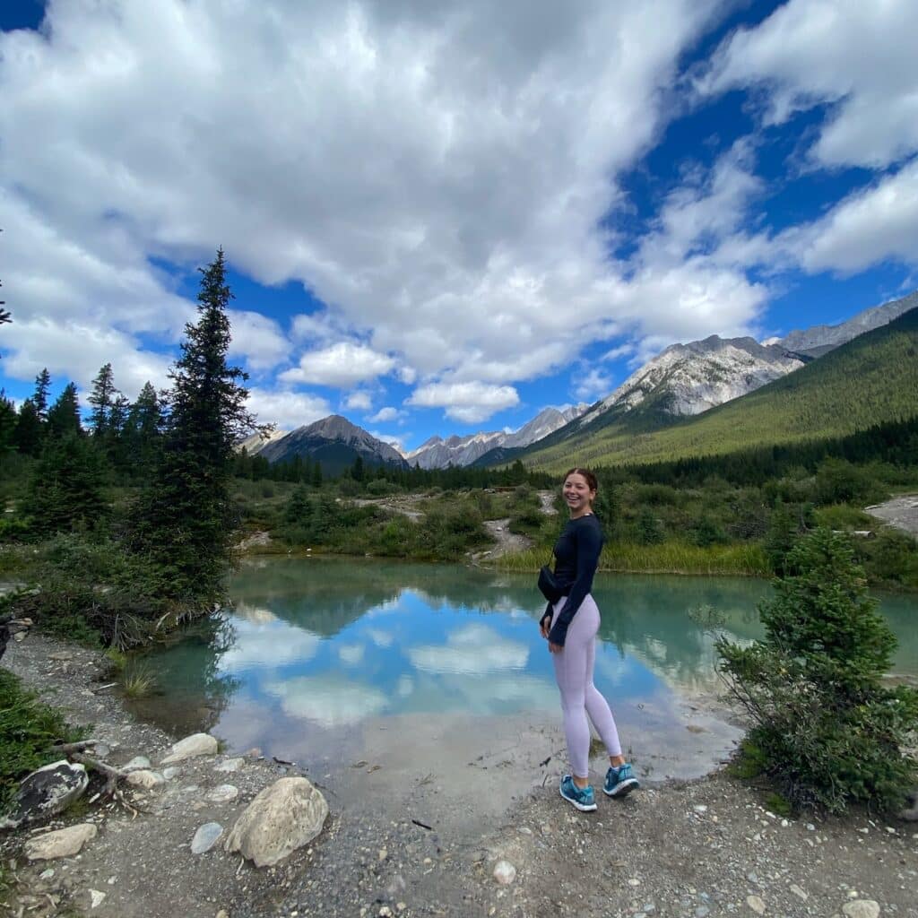 Lauren Newman standing by a lake and mountains