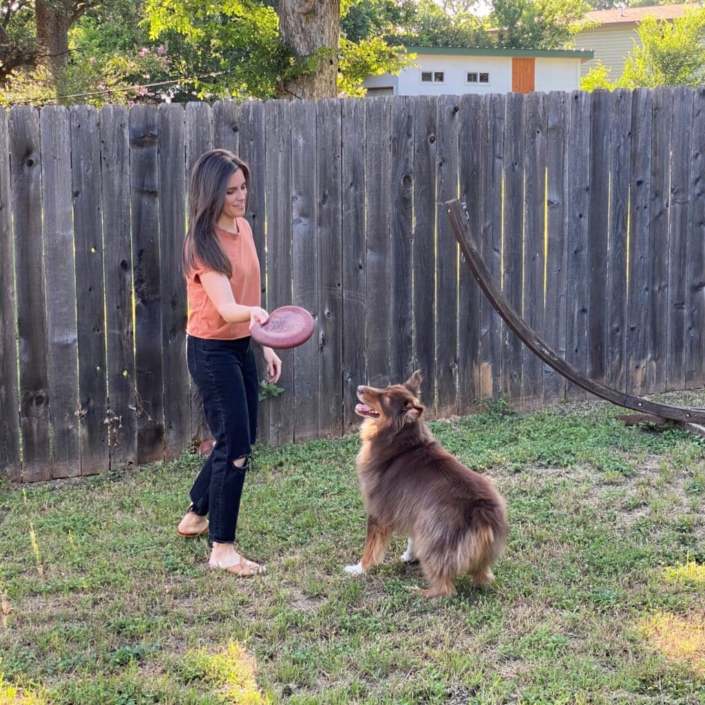 Lisa Shaw playing frisbee with her dog