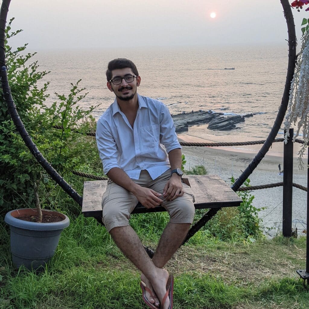 Mohit Vyas sitting on table by the beach during sunset