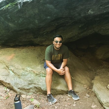 Neiladri Mallick hiking sitting in cave