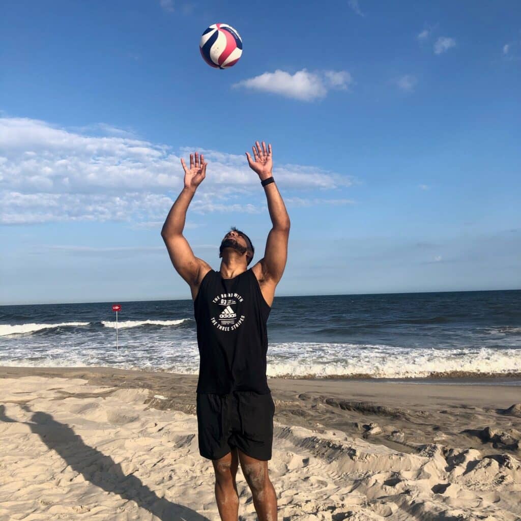 Ryan Bisumber on beach playing volleyball