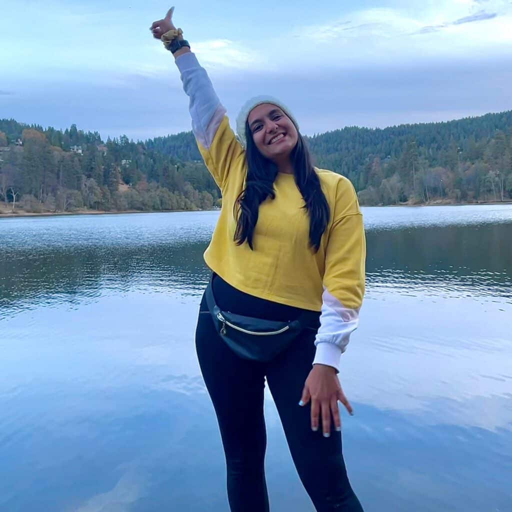 Shreya Shah standing on a log in a body of water