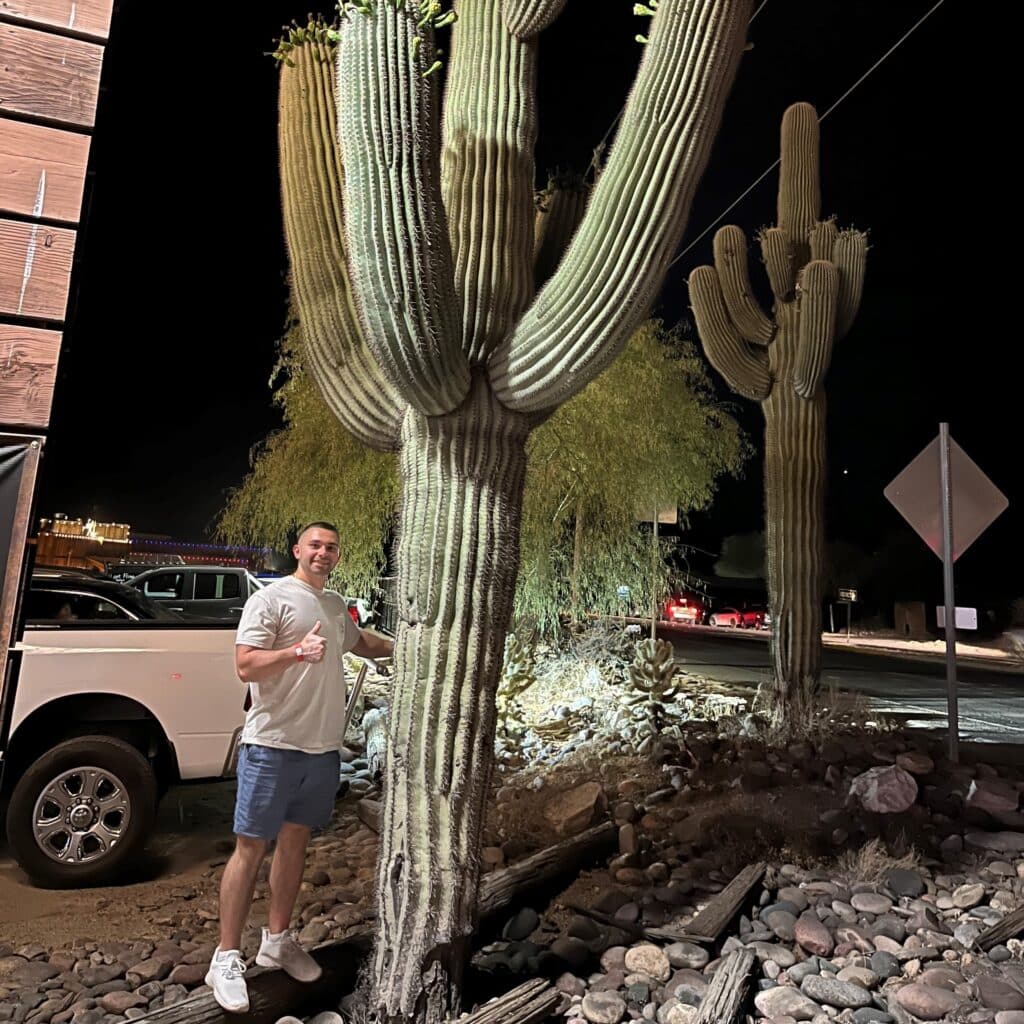 Stratton Drivanos doing thumbs up next to a big cactus